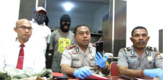 Kapolres Jayapura Kota, AKBP Gustaf R Urbinas saat menunjukkan barang bukti HP milik korban pembunuhan di Lembah Sunyi, Angkasapura, Distrik Jayapura Utara