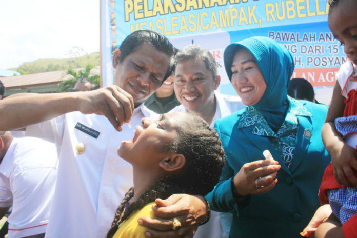 Wakil Bupati Jayapura, Giri Wijayantoro, ketika memberi imunisasi kepada salah satu anak, sebagi tandan Launching Imunisasi MRP, di SMP Negeri 2 Sentan