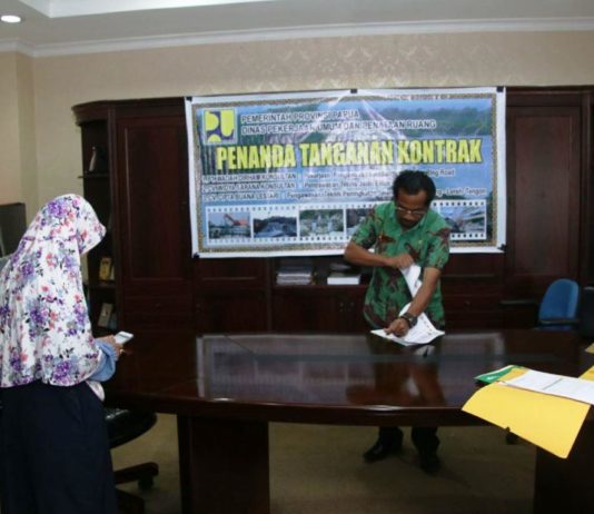 Caption: Kepala Dinas PUPR Provinsi Papu, Djuli Mambaya, ST sobek berkas salah satu perusahaan yang batal kontrak di ruang kerjanya, Kamis (23/8/2018). Foto: Ist / PapuaSatu.com