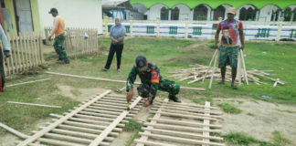 Bhabinsa Merauke bersama warga saat melakukan karya bhakti pembuatan pagar