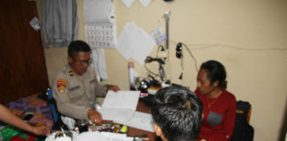 Helga F Sembor (25) (Baju merah) salah satu Honorer Humas Setda Kabupaten Puncak Jaya saat melaporkan oknum polisi berininsial Bripda DN atas penganiayaan yang dilakukan, pada Senin (12/11/2018).