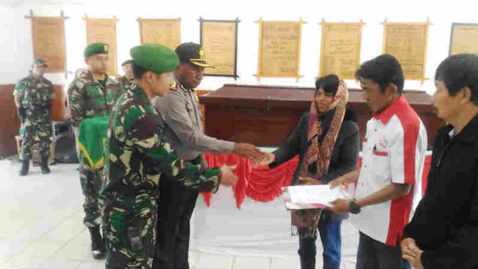 Caption : Kapolores Jayawijaya AKBP Yan Piter Reba bersama Dandim 1702/JWY Letkol Inf. Candra Dianto saat menyerahkan jenazah Alm Matius Palinggih kepada Pt. IStaka Karya di Aula Ukamearek Aso Makodim 1702/JWY, pada Selasa 11 Desember 2018 pagi