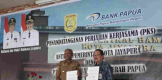 Caption foto : Wali Kota Jayapura Benhur Tomi Mano bersama Direktur utama Bank Papua F Zendrato lakukan MoU dalam pembayaran Non tunai di Pasar Hamadi