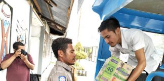 Caption: Staf Pemerintah Kabupaten Keerom saat mengangkut bahan pokok yang akan disumbangkan kepada korban banjir bandang di Sentani Kabupaten Jayapura.