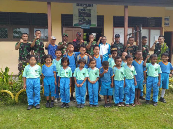 Caption : Prajurit Satgas Yonif 126/KC Pos Kotis bersama masyarakat saat foto bersama usai kerja bhakati Jumat (01/03/2019).