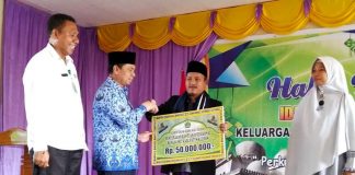 Caption: Bupati Keerom Muh Markum didampingi Kepala Kantor Kementerian Agama Kab Keerom Karel Mambay saat menyerahkan bantuan operasional kepada Majelis Ulama Indonesia Kab Keerom pada saat acara halal bihalal Kantor Kementerian Agama Kab Keerom.