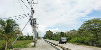 Caption: Tampak tiang listrik milik PLN yang hingga kini belum dipindahkan di jalan Arso Swakarsa.