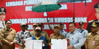 Caption: Bupati Keerom Muh. Markum, Kakanwil Papua Kemenkumham Iwan Santoso dan Ondoafi Bate saat menunjukkan perjanjian yang telah ditandatangani, sebagai salah satu rangkaian dalam acara pelatakan batu pertama pembangunan Lapas Perempuan dan Lapas Khusus Anak.