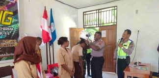 Caption : Kapolsek Abepura, AKP Clief Gerard Duwith, S.IK saat mengenakan helm di kepala salah satu siswa SMA N 1 Abepura kota Jayapura, Senin (20/1/2020) siang