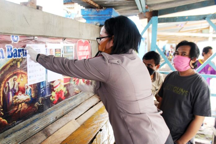 Kasubag Humas Polres Biak Numfor, Iptu Amelia Rumbiak, SIP saat memasang selebaran himbauan pencegahan Virus Corona, Kamis (30/4/2020)