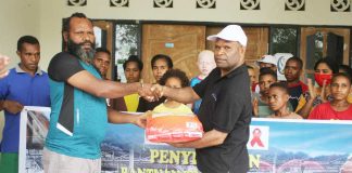 Caption : Ketua Harian KPA Provinsi Papua, Yan Matuan, saat menyerahkan secara simbolis bantuan bahan makanan kepada Ketua Harian Panti Asuhan Air Hidayat Arso 9 kabupaten Keerom, Selasa (12/05/2020)