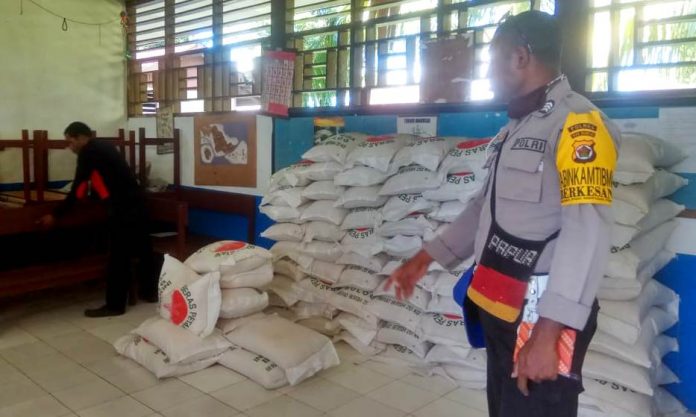 Bhabinkamtibmas Brigpol Welmus Mansumbre saat melakukan pengamanan pembagian sembako kepada masyarakat Kelurahan Saramom, Distrik Biak Kota, Kamis (7/5/20)