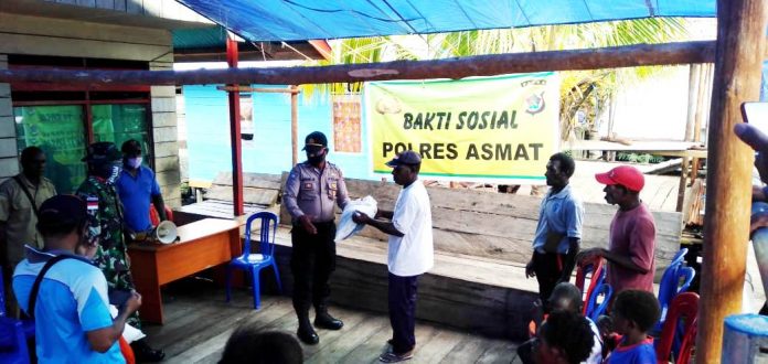 Aparat Polres Asmat saat menyalurkan bantuan Sembako berupa beras dari Kapolri, untuk warga terdampak Covid-19 di Distrik Agats Kabupaten Asmat, Selasa (2/6/20)