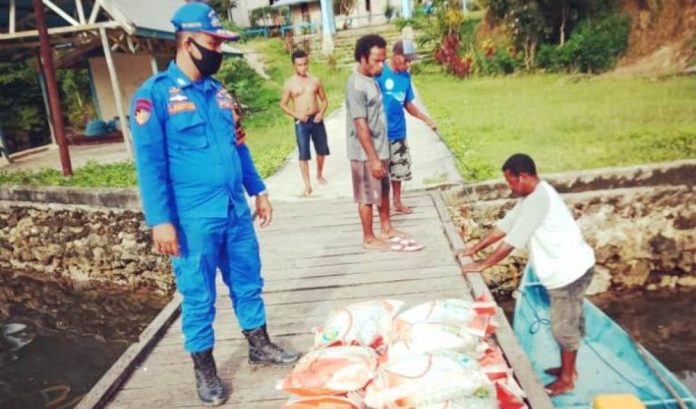 Personil Satuan Polairud Polres Supiori saat mendistribusikan beras bantuan dari Mabes Polri kepada masyarakat yang terdampak Covid-19 di Kepulauan Aruri, Supiori Selatan, Jumat (5/6/2020)