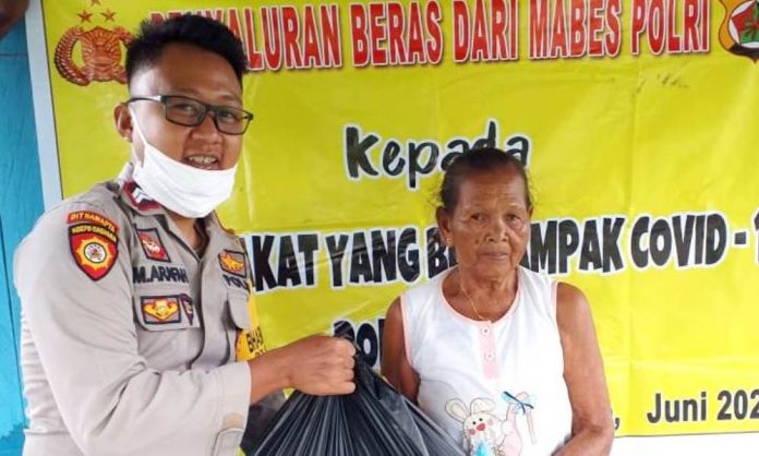 Bhabinkamtibmas Kampung Tamat Sari SP 5 Briptu Muh. Arafah saat membagikan bantuan sembako kepada warga binaannya di Kampung Tamar Sari Distrik Bonggo Timur Kabupaten Sarmi