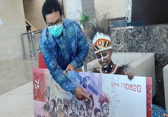 Kepala KPw BI Provinsi Papua, Tigor Naek Sinaga saat memperkenalkan Agustinus Rumere, dengan menunjuk gambarnya di uang Rp.75 ribu, Selasa (25/8/20)