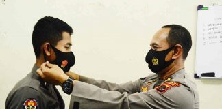 Caption : Kabid Humas Polda Papua Kombes Pol. Drs. Ahmad Musthofa Kamal, SH saat mengenakan Masker kepada salah satu anggota Polda Papua