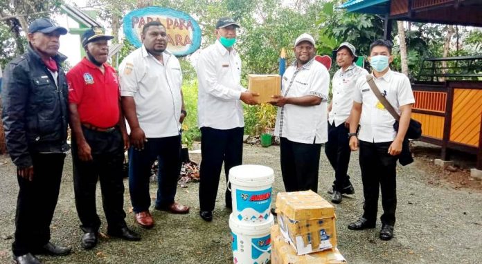 Plt. Kadis Kominfo Kabupaten Jayapura, Gustaf Griapon saat menyerahkan bantuan buku dan cat untuk perpustakaan Kabupaten Jayapura dan taman baca, Rabu (2/9/20)