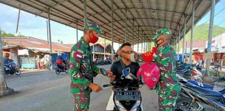 Caption : Prajurit Kodim 1709/Yawa saat membagikan masker di sepanjang jalan-jalan protokol Kota Serui Kabupaten Kepulauan Yapen, pada Senin (19/10/2020).