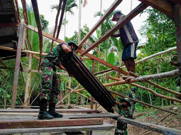 Caption : Terlihat Prajurit TNI saat membantu membangun rumah milik Frans Sebo (50) di Kampung Yuwainda, Distrik Waris, Kabupaten Keerom, Provinsi Papua (04/11/2020).