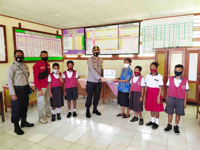 Caption : Kapolres Supiori AKBP I Made Budi Darma, SE, saat membagikan buku tentang polri kepada sejumlah siswa SD di kabupaten Supiori