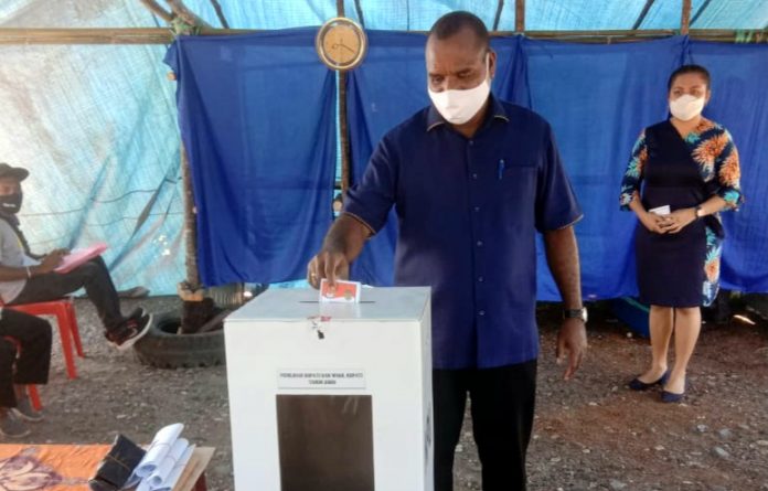 Kandidat nomor urut 4, Yeremias Bisai, selaku Bupati Waropen saat memasukkan surat suara yang telah dicoblosnya di TPS 2 Kampung Waren 2, Rabu (9/12/20)