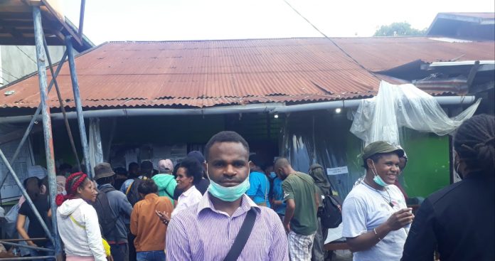 Ketua HMPJ berdiri di tengah mahasiswa dan masyarakat asal Jayawijaya yang urus tiket di kantor Perwakilan Sentani, Rabu (23/12/2020)