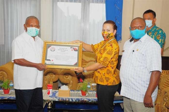 Ketua KPID Papua, Rusni Christine Abaidata saat menyerahkan penghargaan kepada Bupati Jayapura Mathius Awoitauw, SE, M.Si, yang disaksikan Wakil Ketua KPID Provinsi Papua Eveerth Zacharias Joumilena dan Kepala Dinas Kominfo Kabupaten Jayapura, Gustaf Griapon di VIP Room Kantor Bupati Jayapura, Jumat (13/11)