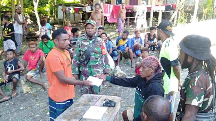 Caption : Kepala Kampung Wanampompi bersama Babinsa Koramil 1709-01/Yapsel Serka Robert Bosayor dan Sertu Ruben Luis Way, saat menyerahkan bantuan kepada ketua Karang Taruna Kampung Wanampompi, Distrik Angkaisera, Kabupaten Kepulauan Yapen, Senin (28/12/2020).