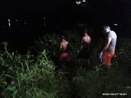 Caption : Anggota Polres Jayapura dan Polsek Kota saat mengevakuasi korban dari pinggir Danau Sentani menuju RSUD Yowari, Minggu (07/02/2021).
