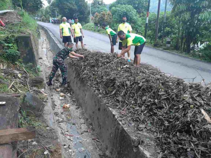 Caption : Tampak Kabintaldam XVII/Cenderawasih Letkol Arh Antonius Andre bersama anggota, saat melakukan pembersihan jalan di tanjakan menuju Makodam XVII/Cenderawasih, Kamis (18/02/2021) tadi pagi.