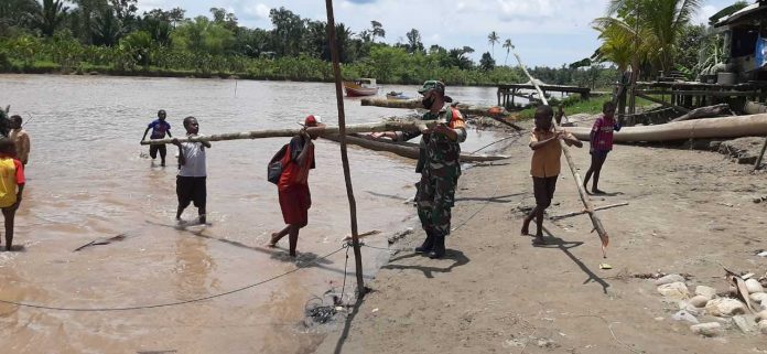 Caption : Babinsa Koramil 1710-07/Mapurujaya, Koptu Redemtus Riyanto, saat membantu warga untuk membangun Rumah AdatKarapo, pada Minggu (21/02/2021)