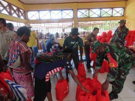 Caption : Satuan TNI Mimika dan Kemensos RI, saat membagikan 400 Paket Sembako Kepada Masyarakat, di balai Kampung Pioka Kencana, Rabu (16/06/2021). Foto : (Pendam/PapuaSatu. com)