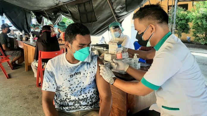 Salah satu warga saat menerima vaksin Covid-19 dalam vaksinasi massal di halaman Mapolsek Sentani Kota, Rabu (1/9/21)