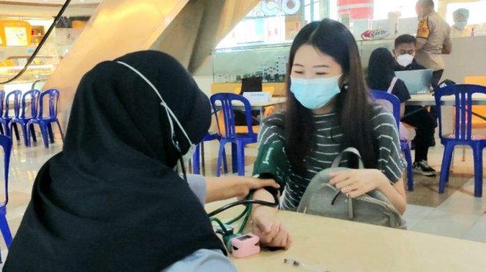 Proses screening untuk warga yang hendak divaksin Covid-19 di Hypermart, Tanah Hitam, Abepura