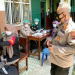 Dir Reskrimsus Polda Papua, Kombes Pol. Ricko Taruna Mauruh, S.IK., bersama Ketua PWNU Provinsi Papua Dr.H. Toni Wanggai saat berbincang-bincang dengan warga yang mengikuti vaksinasi Covid-19 di Halaman SMP Nurul Huda, Kota Jayapura