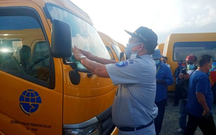 Kepala PT Jasa Raharja Cabang Papua dan Papua Barat, Tamrin Silalahi, secara simbolis memasang stiker SWDKLLJ pada salah satu kendaraan bus untuk operasional PON XX dan Peparnas XVI Tahun 2021 Papua, Senin (6/9)
