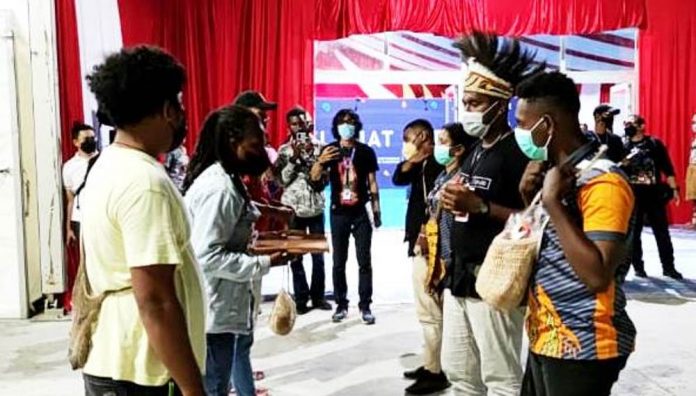 Pengalungan noken dan pemakaian mahkota khas apua pada simulasi penerimaan Kontingen PON di sekretariat sub PB Pon Kabupaten Jayapura, Sabtu (18/9/2021)