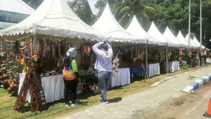 Deretan stand UMKM yang menjual hasil kerajinan tangan khas Papua dan pernak pernik PON XX Papua 2021 di pinggir Jalan Raya Abepura-Sentani, Kampung Harapan