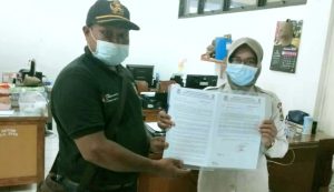 Pdt. Hisage bersama staf Direskrimum Polda Papua menunjukkan laporan kasus pencemaran nama baik, Kamis (7/10/21)