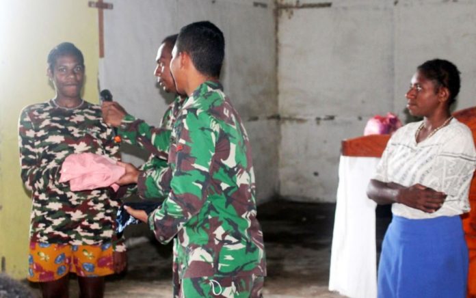 Personel Satgas TMMD Ke-112 Kodim 1707/Merauke saat membagikan baju layak pakai kepada para remaja dan anak-anak, bertempat di kampung Okor, Distrik Haju Kabupaten Mappi, Selasa (05/10/2021)