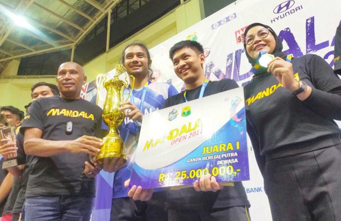Caption : Wali Kota Jayapura Benhur Tomi Mano DR. Drs. Benhur Tomi Mano MM didampingi Owner PB Mandala Ny. Farida Maswi saat menyerahkan piala dan medali kepada Perwakilan juara I Beregu Dewasa, Berry dan Juan di GOR Cenderawasih, Senin (14/03/2022). Caption : Wali Kota Jayapura Benhur Tomi Mano DR. Drs. Benhur Tomi Mano MM didampingi Owner PB Mandala Ny. Farida Maswi saat menyerahkan piala dan medali kepada Perwakilan juara I Beregu Dewasa, Berry dan Juan di GOR Cenderawasih, Senin (14/03/2022).