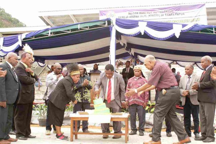 Caption : Ketua Panitia Penyelanggara, Pdt. Ev. Merlis Eselo S.Th bersama Ketua Sinode Kingmi di Tanah Papua, Pdt. Tilas Mom, S.Th.,MA bersama para ketua Klasis, saat memotong kue Ulang Tahun Gereja Kingmi ke-60 tahun