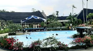 3.Pemandangan Suni Garden Lake Hotel & Resort by Parkside – Sentani dengan kolam renang di tengahnya yang membuat rileks para tamu