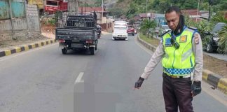 Caption : Salah Satu anggota Polsek Abepura saat menunjukan lokasi korban kecelakaan tunggal hingga mengakibatkan meninggal dunia di Jalan Raya Sentani, Minggu 26 Juni 2022 pagi.