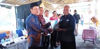 Bupati Jayapura, Mathius Awoitauw,SE,M.Si saat membagikan buku Gugus Tugas Masyarakat Adat (GTMA) kepada pemateri dan peserta sarasehan yang hadir.