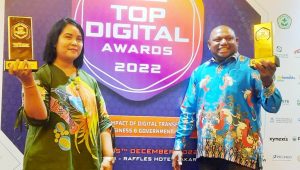 Asisten I Setda Kabupaten Jayapura, Elvina Situmorang bersama Kadis Kominfo Kabupaten Jayapura, Gustaf Griapon,ST saat menerima penghargaan TOP Digital Awards 2022