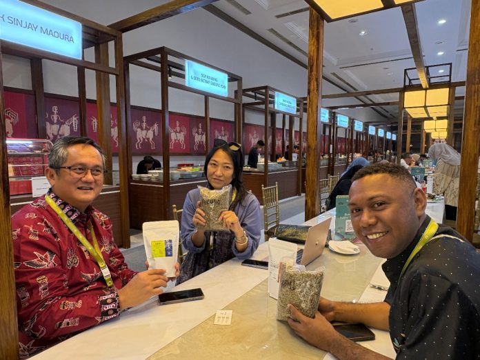 Kepala KPw BI Papua, Faturachman bersama pengelola Koperasi Emas Hijau Papua menunjukkan produk kopi yang ditampilkan pada ajang KKI 2025 di JICC
