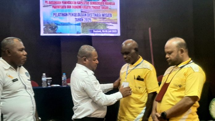 20250716_102129 Wakil Bupati Jayapura, Haris Richard Yocku mengalungkan tanda peserta saat membuka pelatihan manajemen pengelolaan destinasi wisata