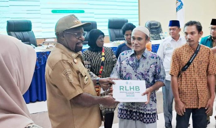 Bupati Jayapura, Yunus Wonda saat menyerahkan program rehab Rumah Layak Huni Baznas (RLHB) dari Baznas Kabupaten Jayapura kepada penerima manfaat, Selasa (9/9/25)
